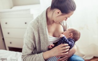 Young mother breastfed her baby girl. Mother breastfed baby at the bedroom