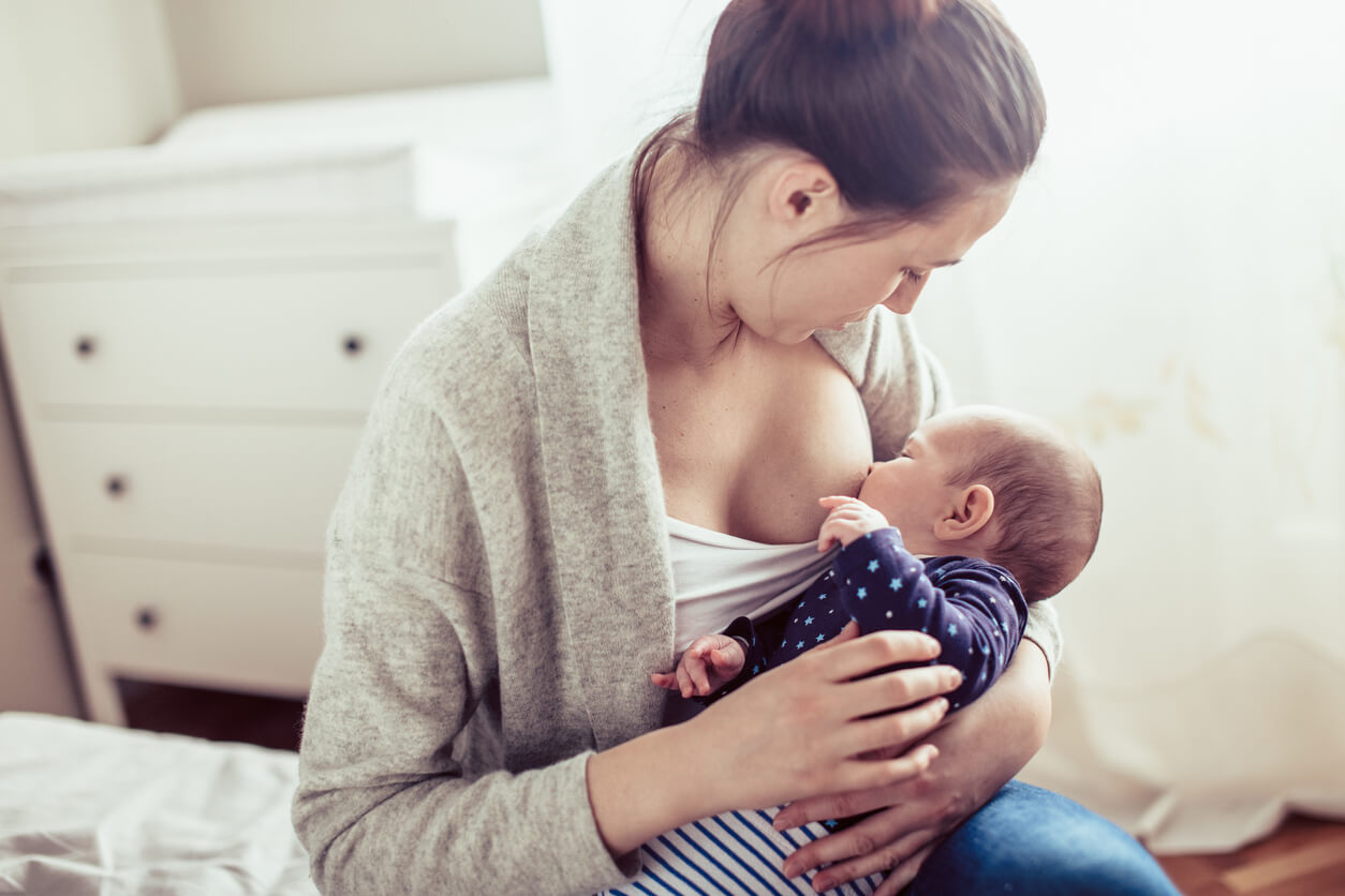 Young mother breastfed her baby girl. Mother breastfed baby at the bedroom
