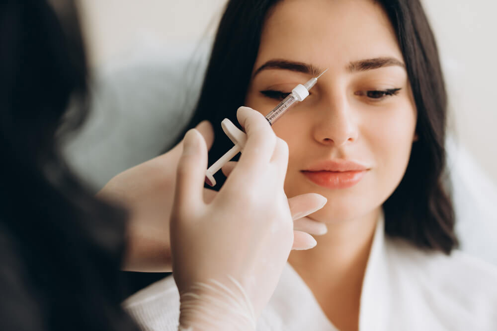 Young Woman Getting Botox Cosmetic Injection in Forehead