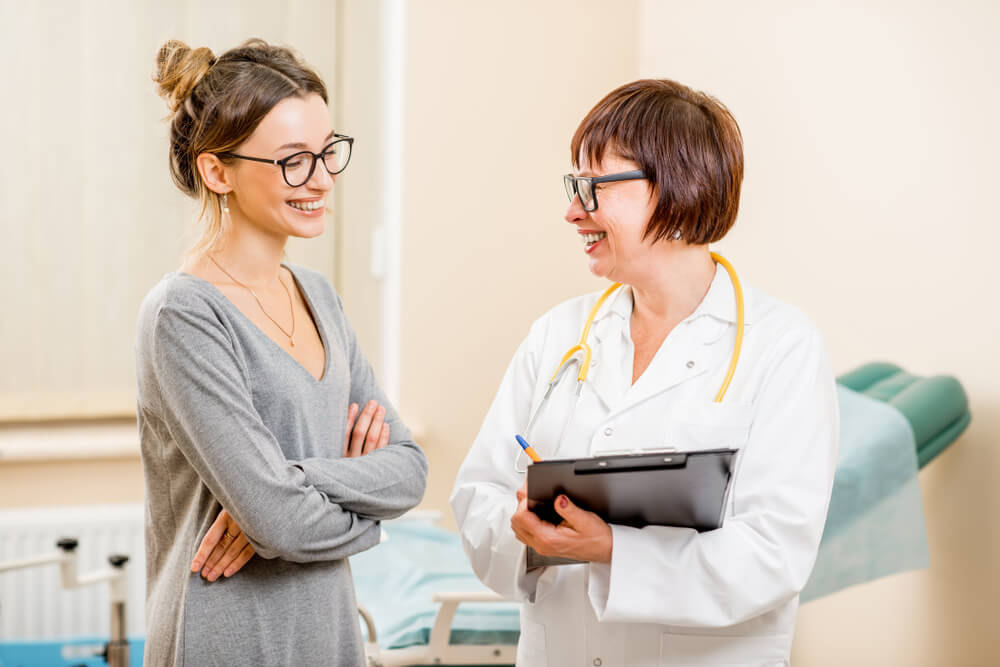 Portrait of a Young Woman Patient With a Senior Gynecologist During the Consultation in the Office